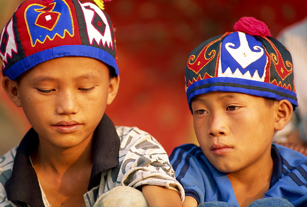 Portrait of two Hmong Hill tribe boys wearing traditional hats in Luang Prabang province, Laos, Indochina, Southeast Asia, Asia