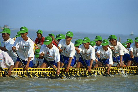 Men wearing baseball caps rowing a boat during the Water Festival in Phnom Penh, Cambodia, Indochina, Southeast Asia, Asia