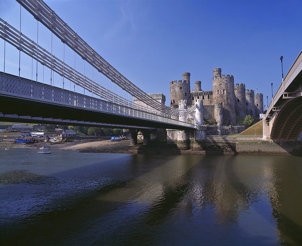 Telford Suspension Bridge, opened in 1826, crossing the River Conwy with Conwy Castle, UNESCO World Heritage Site, beyond, North Wales, United Kingdom, Europe