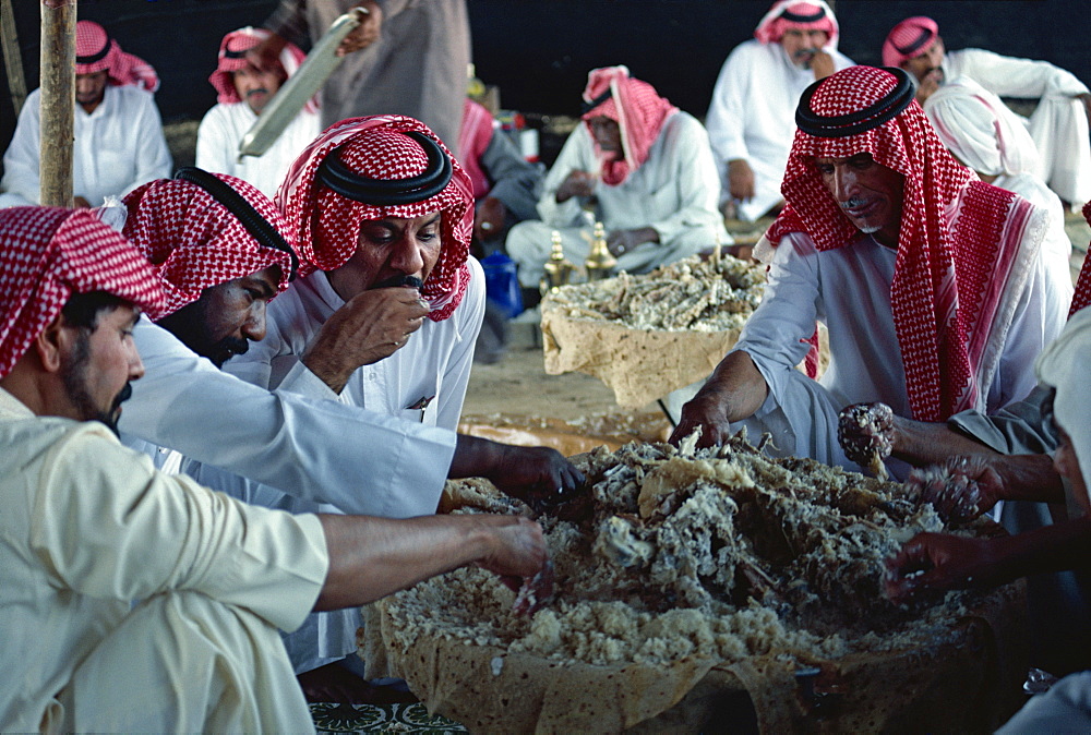 Group of men eating at a Bedouin feast, Saudi Arabia, Middle East