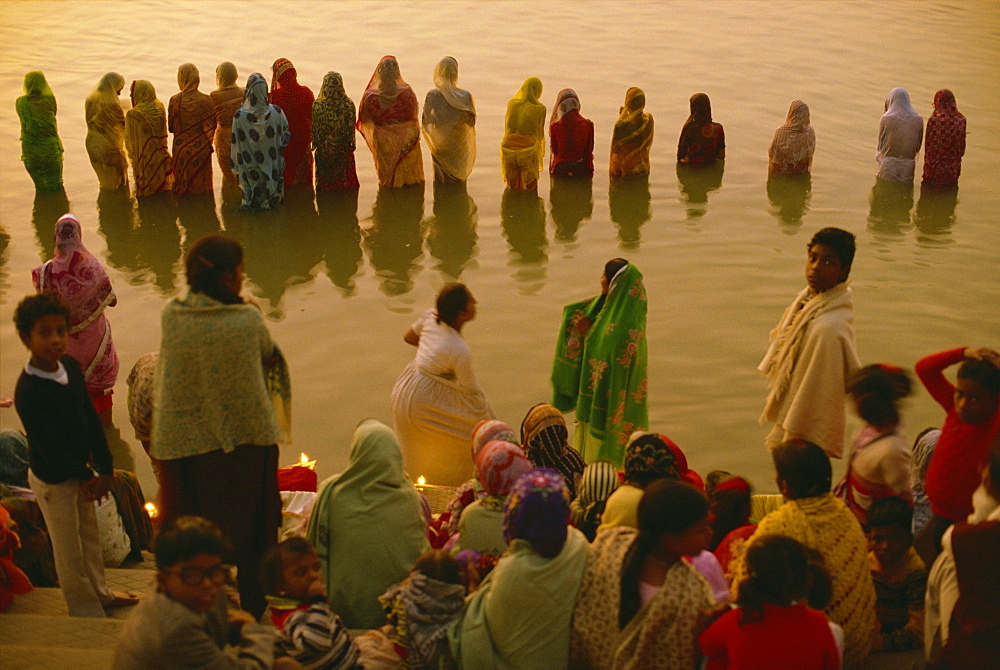 Hundreds of women gather in rows along river front, defying the cold, to welcome the rising sun god, Surya, Sun Worship Festival, Varanasi, Uttar Pradesh state, India, Asia