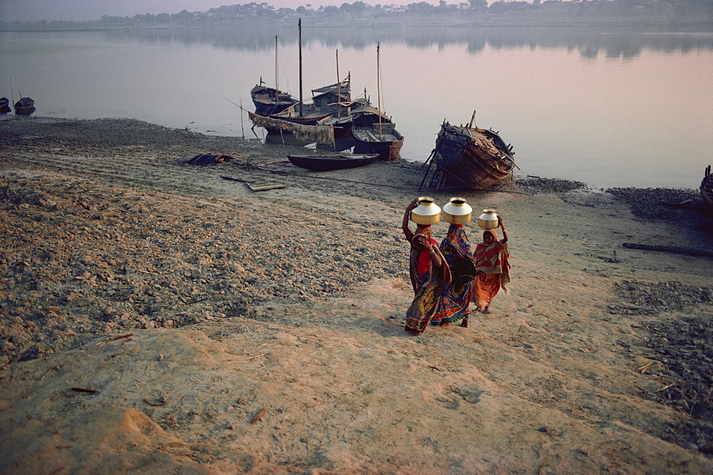 Women carry brass pots filled with holy Ganga water, India, Asia