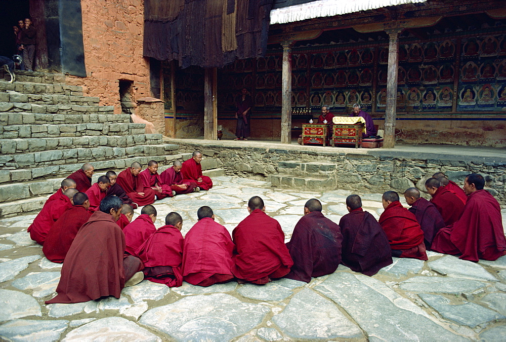 A group of young novice monks sitting in a circle during an oral examination, at Tashilunpo Monastery, Xigaze, Tibet, China, Asia