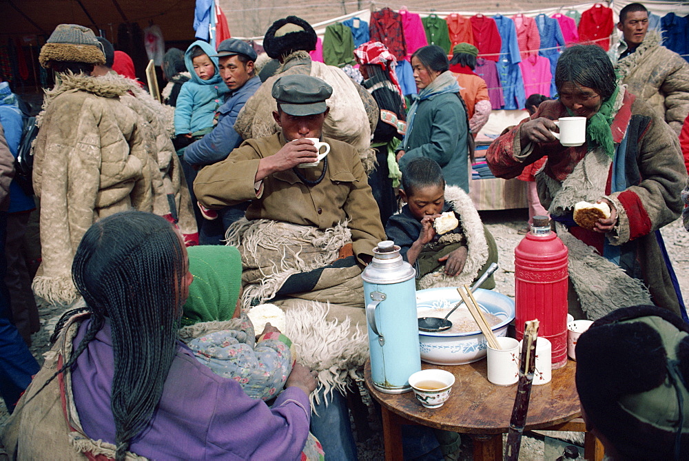 A group of Tibetans eating at the bazaar at T'Aer Monastery, Qinghai province, Tibet, China, Asia