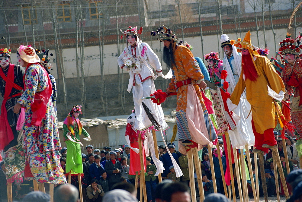 Stilt dancers in parade at New Year celebrations in Qinghai Province, China, Asia