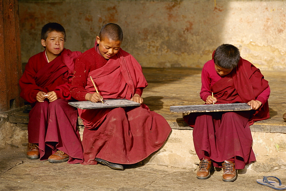 Young Buddhist monks practise writing at Bumthang in Bhutan, Asia