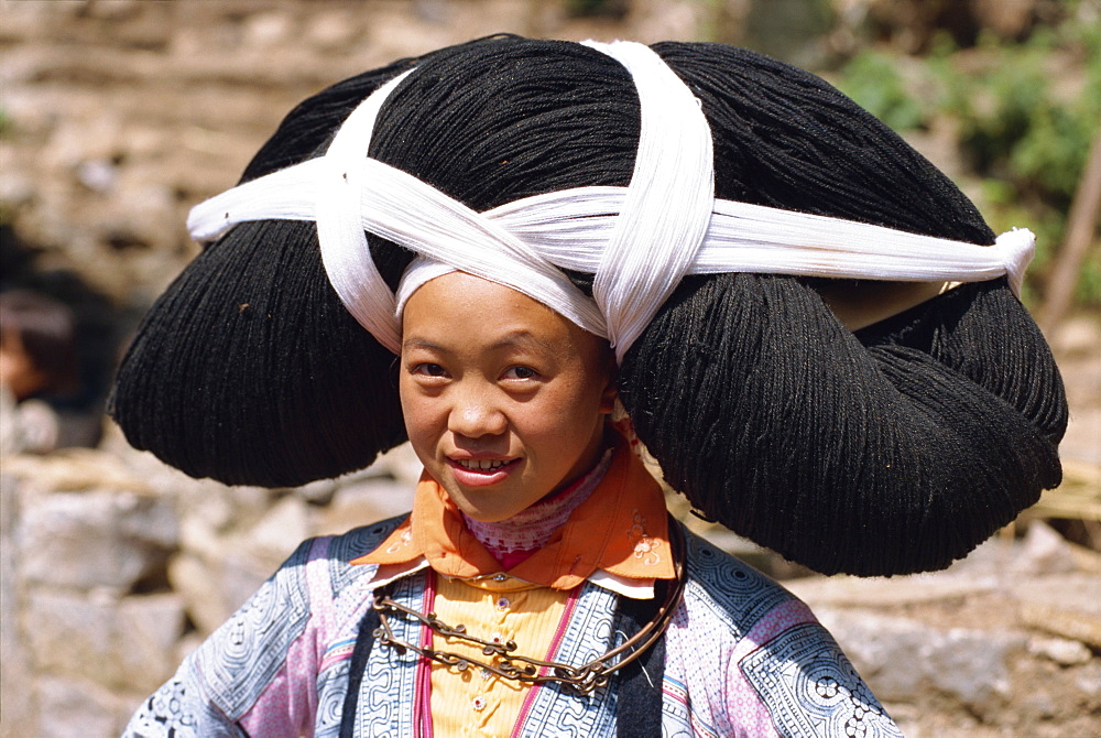 Portrait of a long horned Miao woman with huge head dress, typical of festival wear in central Guizhou, China, Asia