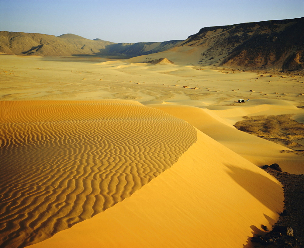 Dunes in canyon near Amguid, vehicle in the distance, Algeria, North Africa