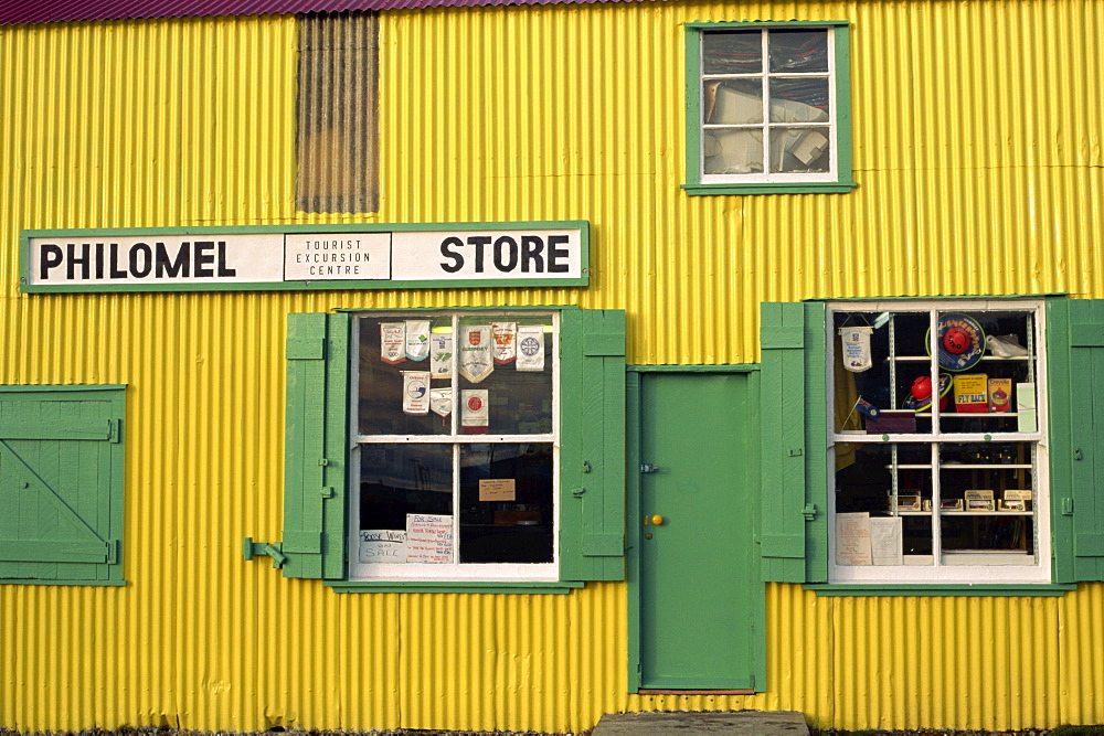 Brightly painted yellow corrugated wall and green wooden building of the general store selling hardware and gifts, Stanley, Falkland Islands, South America