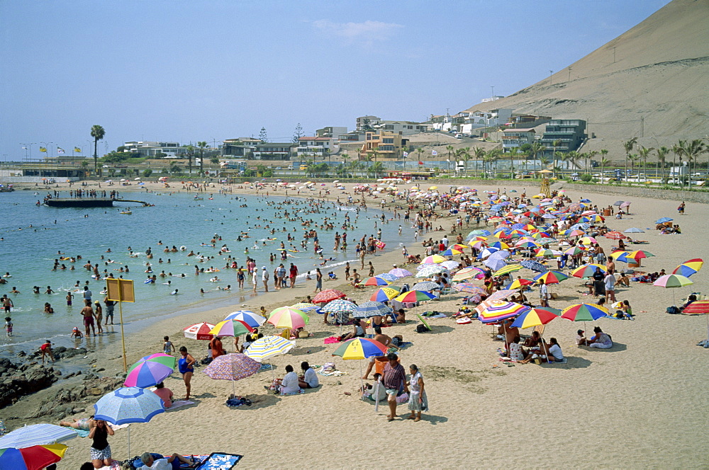 Tourists and holidaymakers crowd the beach at Playa La Lisera, in Arica, Chile, South America