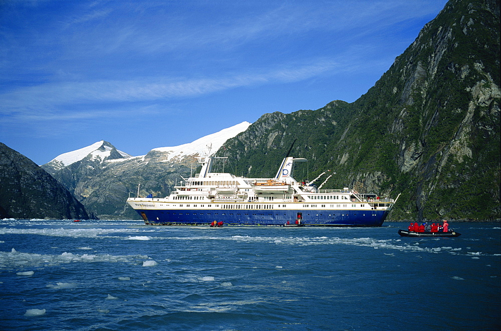 Tourists in an inflatable boat and cruise ship in the Chilean fjords, Chile, South America