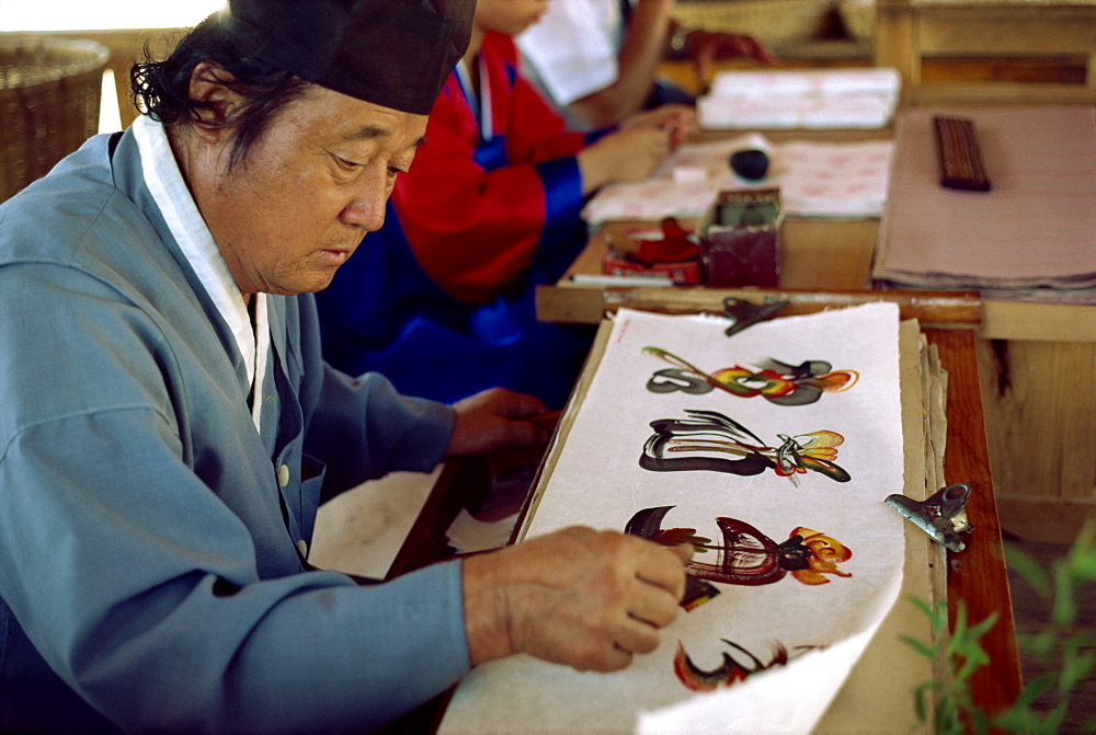 Portrait of a calligrapher at work painting letters in South Korea, Asia