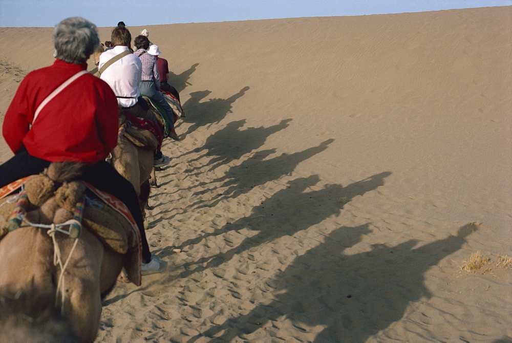 Shadows of tourists on camels, Dunhuang Province, China, Asia