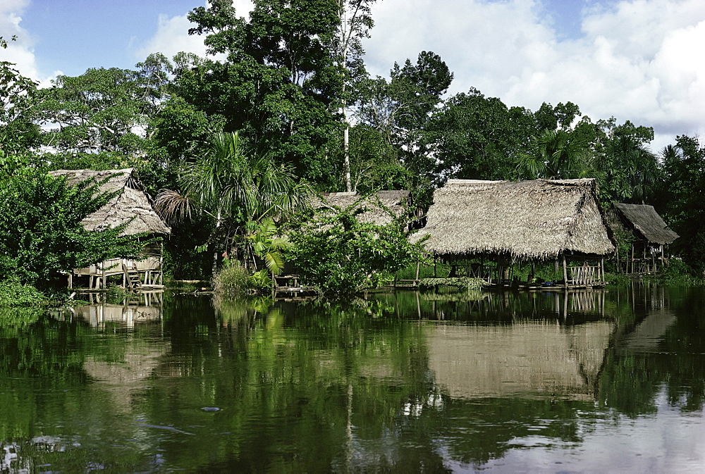 Building on stilts reflected in the River Amazon, Peru, South America