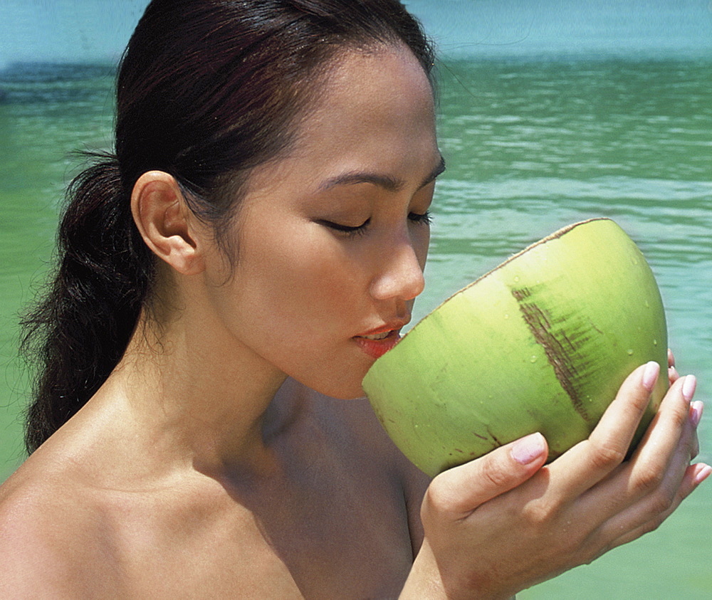 Girl about to drink from coconut