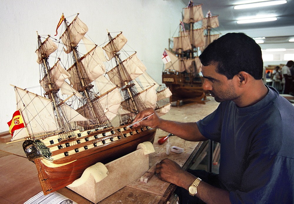 Factory worker making reproduction of old sailing ships in Mauritius, Africa