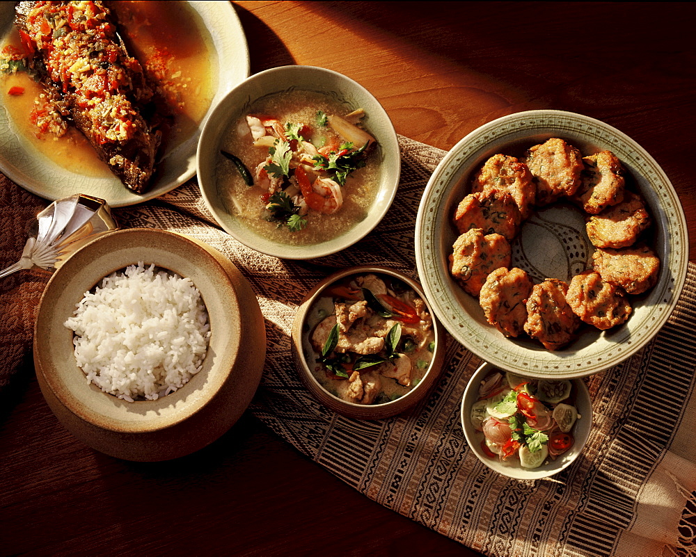 A typical Thai meal balancing spicy, sour and sweet flavours, consisting of spicy thom yam soup, weet and sour fish, fish patties, a curry dish and rice, Thailand, Southeast Asia, Asia