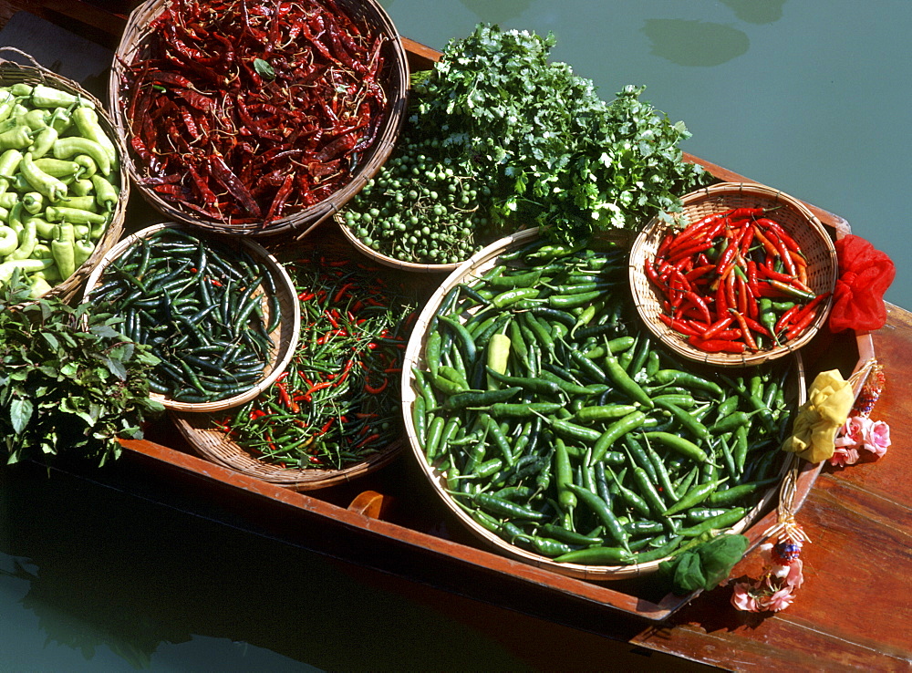 An assortment of chillies, a staple ingredient of Thai cooking, on sale on a boat in a floating market in Thailand, Southeast Asia, Asia