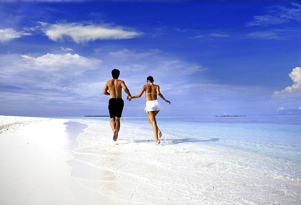 Couple running on a beach, Maldives, Indian Ocean, Asia