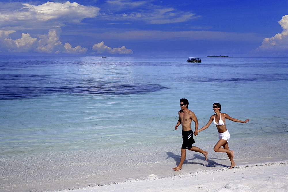 Couple running on a beach, Maldives, Indian Ocean, Asia