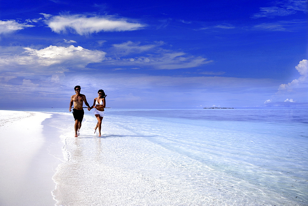 Couple running on a beach, Maldives, Indian Ocean, Asia