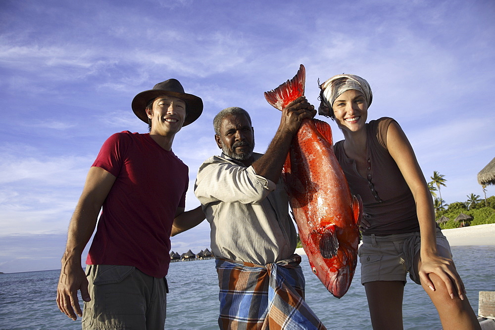 Couple with local fisherman, Maldives, Indian Ocean, Asia