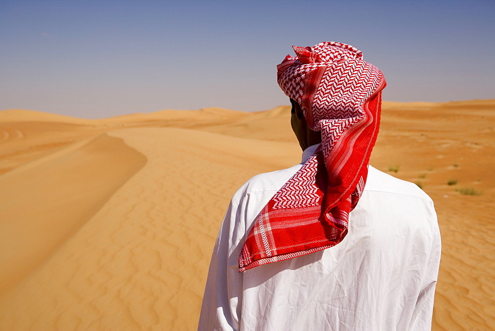 Man in traditional dress in the desert outside Dubai, United Arab Emirates, Middle East