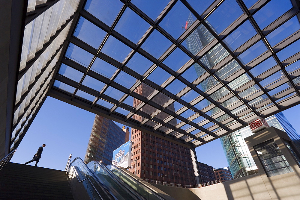 Man walking past subway station in new urban development, and skyscrapers in Potsdamer Platz, Berlin, Germany, Europe