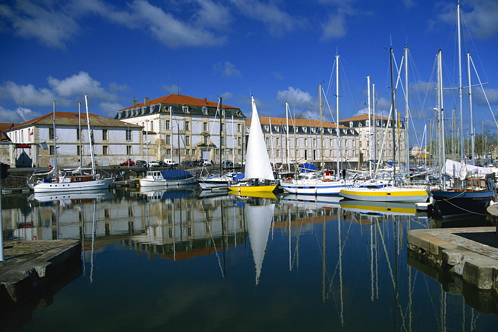 Reflections of boats in the marina with the naval storehouse, (Magasin aux Vivres) behind, at Rochefort, Charente- Maritime, Poitou Charentes, France, Europe