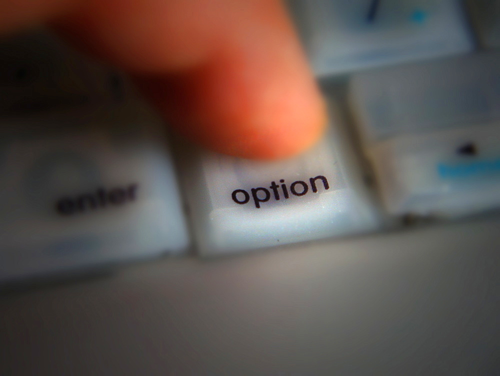 Finger pressing the Option key on a computer keyboard