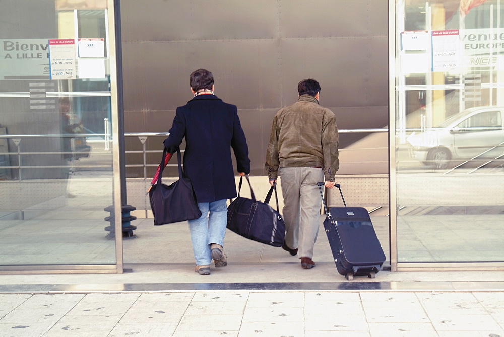 Couple with luggage entering Lille Europe station, Lille, Nord, France, Europe