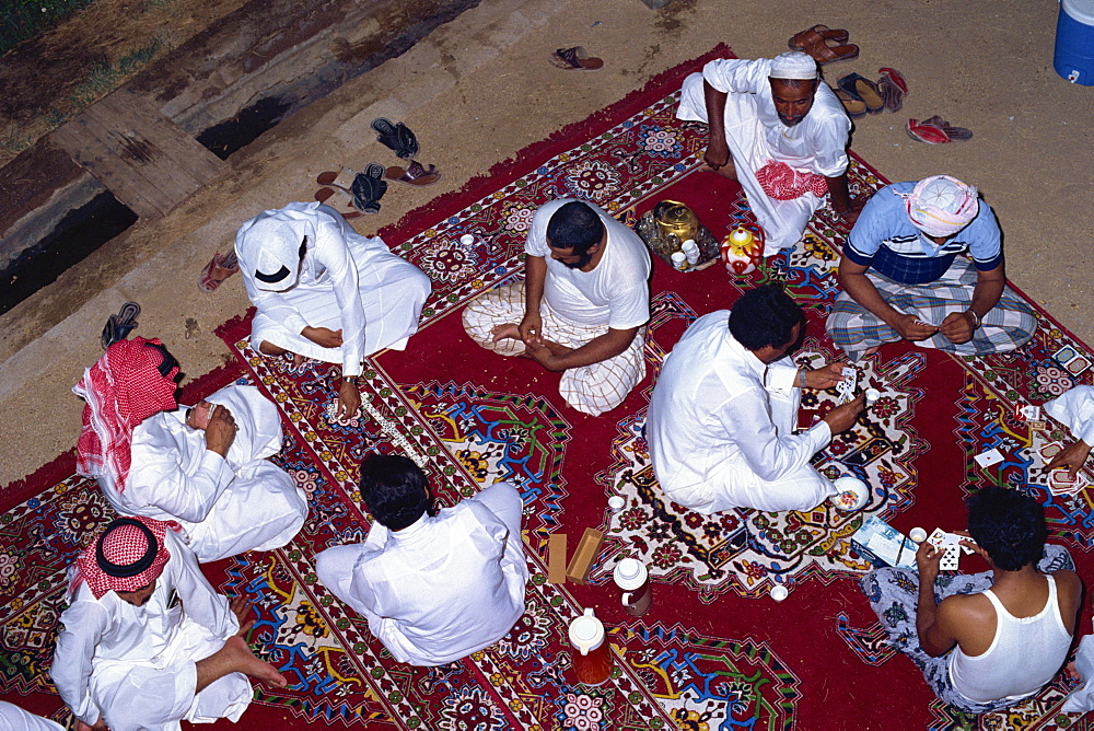 Overhead view of a group of men gathering for tea, cards and dominoes, Saudi Arabia, Middle East