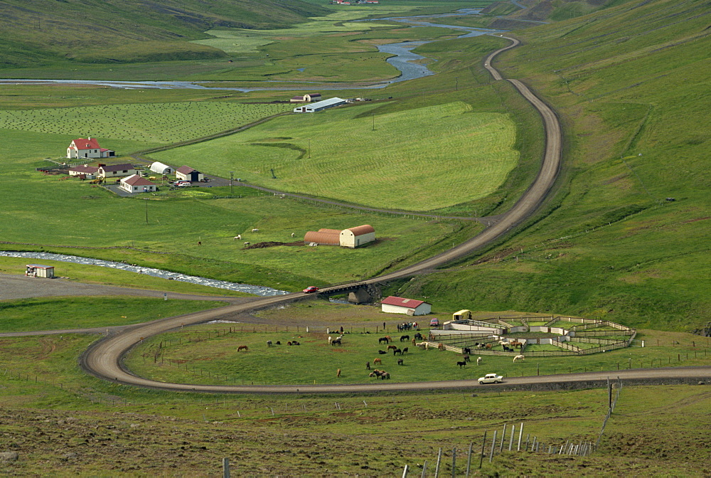 Aerial view of a road and farm with horse pens and fields at Bolstadarhild near the north coast of Iceland, Polar Regions