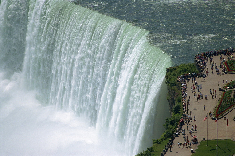 Tourists on viewing platform on Canadian side of the waterfall view the Horseshoe Falls at Niagara, Ontario, Canada, North America