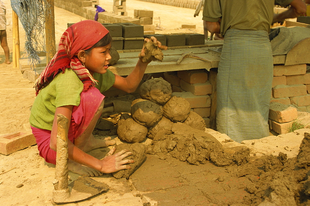 Child labour, young girl moulding lumps of clay at brickworks on Mandalay Plains, Myanmar (Burma), Asia