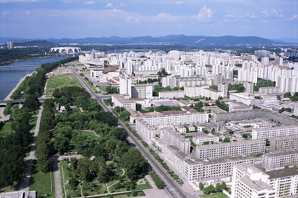 Blocks of flats beside Taedong River, park and distant Mayday Stadium, Pyongyang, North Korea, Asia