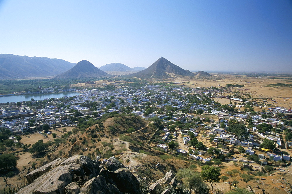 Holy lake beside holy city, with camel fair (mela) on sand dunes, Pushkar, Rajasthan, India, Asia