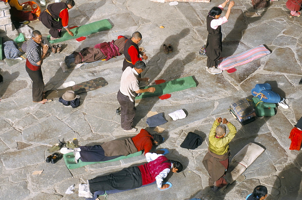 Pilgrims prostrating in front square, Jokhang Buddhist temple, Lhasa, Tibet, China, Asia