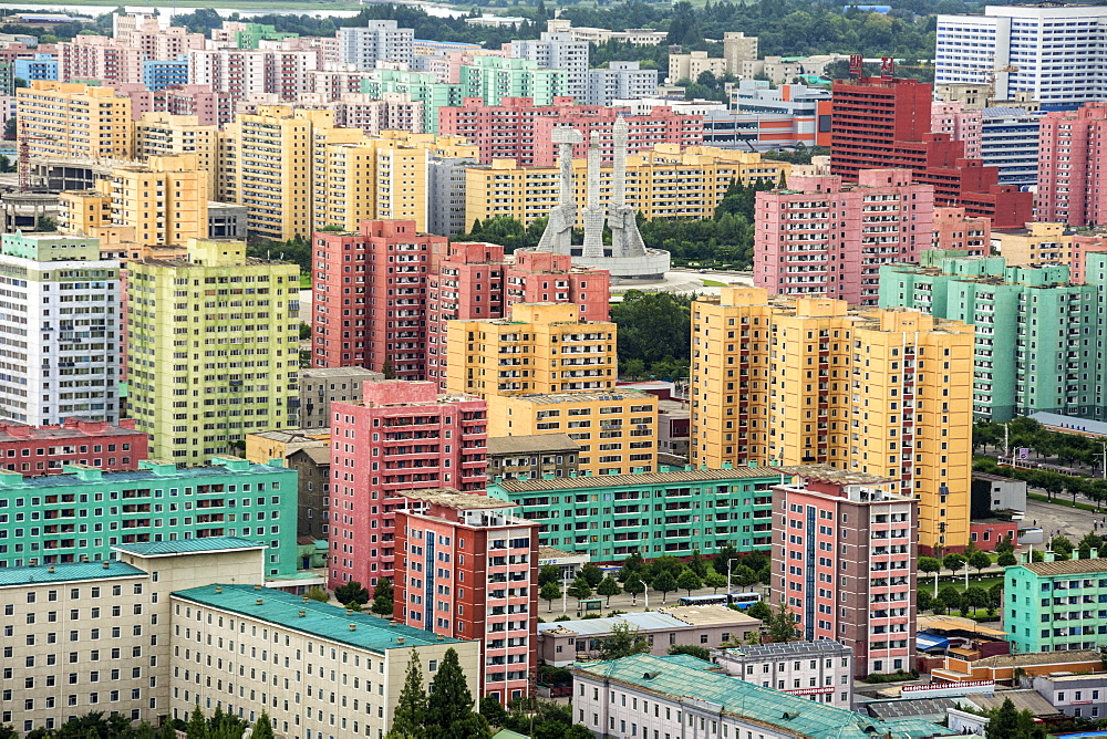 Workers' Party Monument amid painted blocks of flats, seen from Juche Tower, Pyongyang, North Korea, Asia