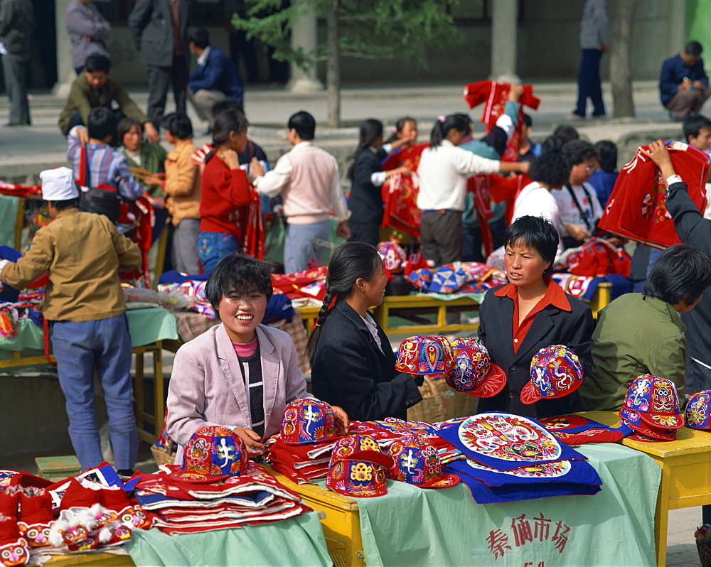 Women selling colourful hats in the market at Xian, Shaanxi, China, Asia