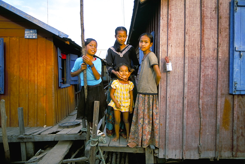 Girls standing by their house, floating fishing village of Chong Kneas, Tonle Sap lake, near Siem Reap, Cambodia, Indochina, Southeast Asia, Asia