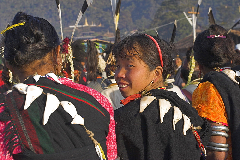 Naga ladies sitting on bench whilst the dignitaries make their speeches, with conch shells strung over their backs, Naga New Year Festival, Lahe village, Sagaing Division, Myanmar (Burma), Asia