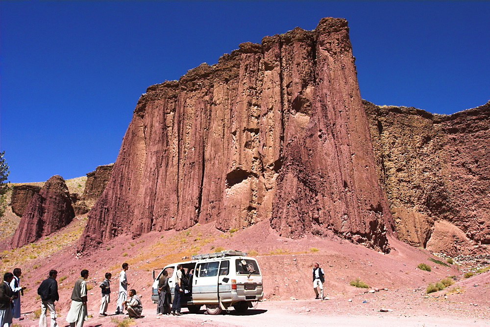 Tourist and locals at the Magenta cliffs near Shahr-e-Zohak (Red City), between Kabul and Bamiyan (the southern route), Bamiyan province, Afghanistan, Asia