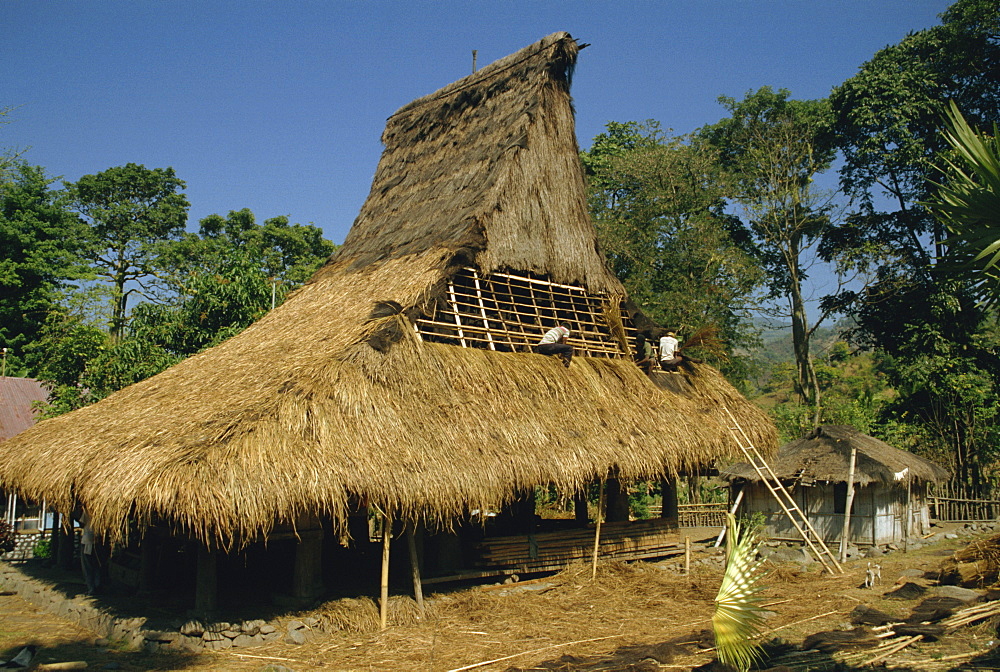 Men thatching the roof of a house near Moni, Flores, Indonesia, Southeast Asia, Asia