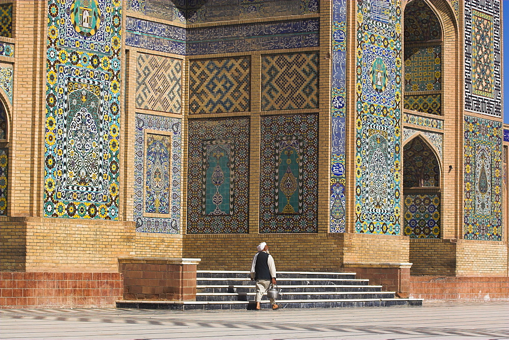 A man carrying a kettle walks past the Friday Mosque (Masjet-e Jam) (Masjid-e Jam) (Masjid-I-Jami), Herat, Afghanistan, Asia