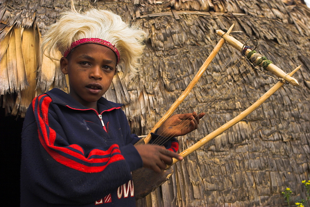 Dorze boy with musical instrument made from bamboo, Chencha mountains, Ethiopia, Africa