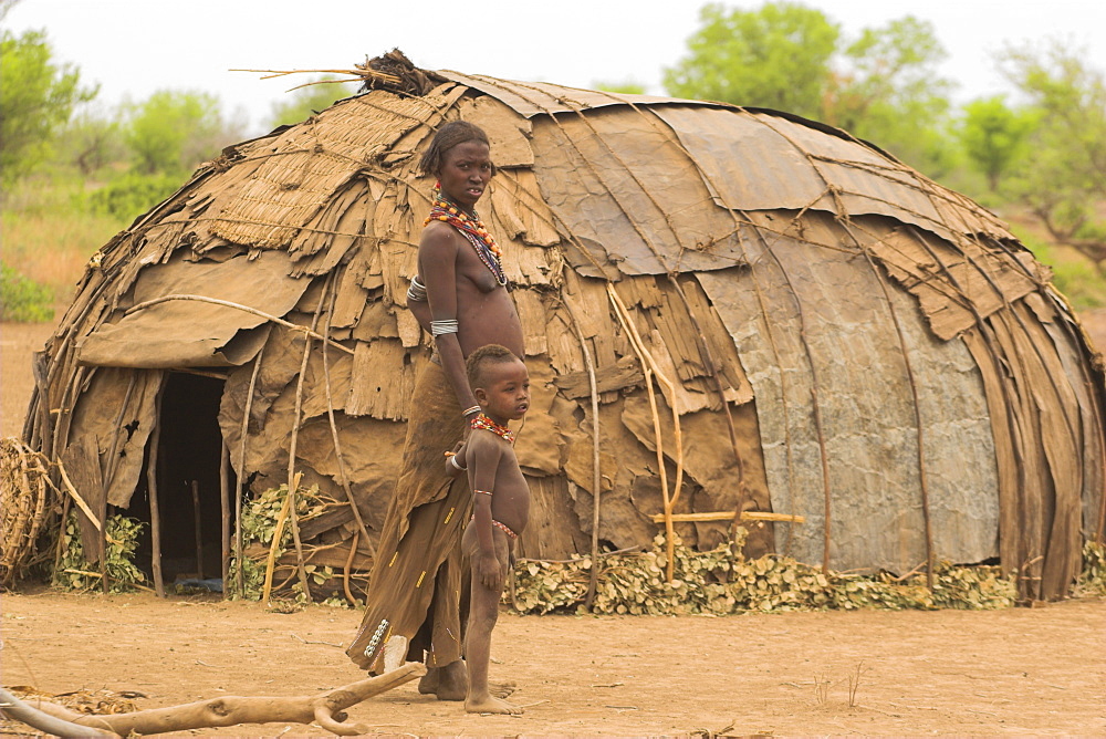 Dassanech woman standing outside her hut, village near Omorate, Ethiopia, Africa