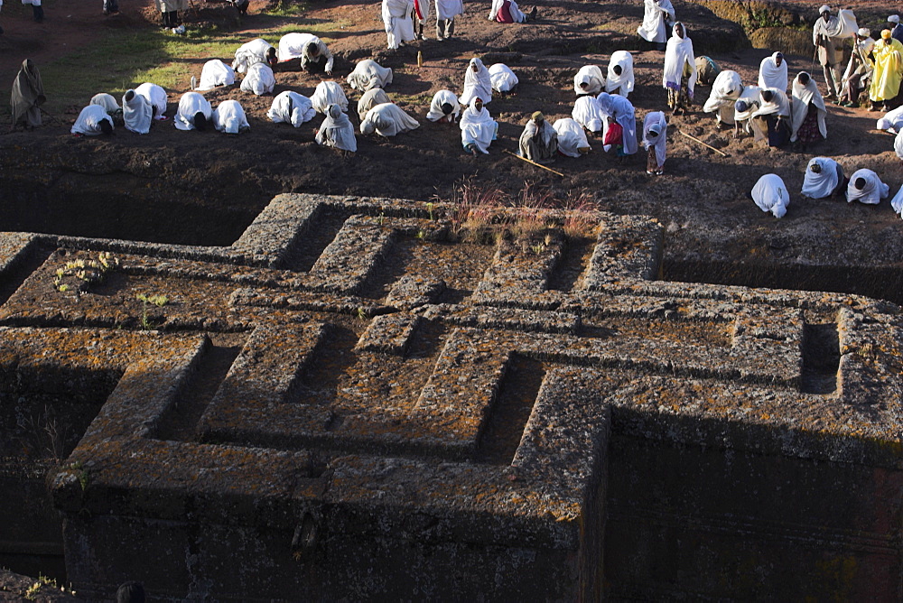 Pilgrims wearing traditonal gabi (white shawl) at festival at rock-hewn monolithic church of Bet Giyorgis (St. George's), roof shaped like a Greek cross, Lalibela, UNESCO World Heritage Site, Ethiopia, Africa