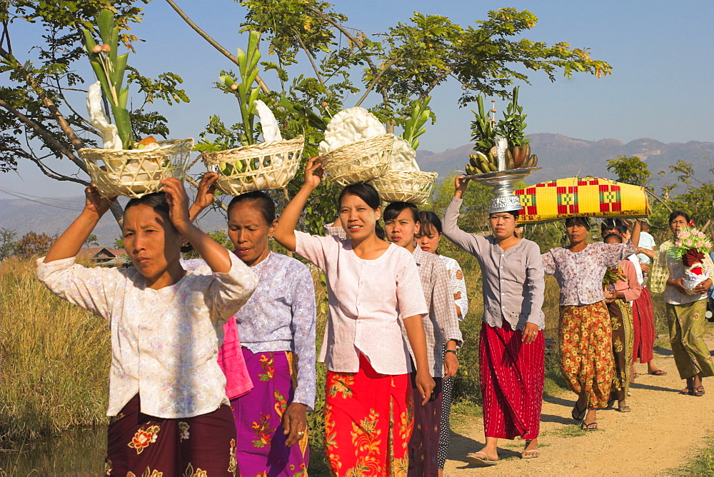 People walking to Monastery carrying offerings on their heads, Novice monk ceremony, Inle Lake, Shan State, Myanmar (Burma), Asia 