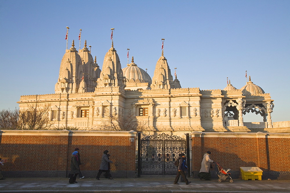 People walking past Shri Swaminarayan Mandir Temple, the largest Hindu temple outside India, winner of UK Pride of Place award 2007, Neasden, London, England, United Kingdom, Europe